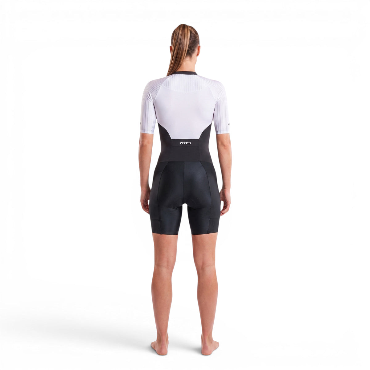 A woman wearing the Zone3 Lava full zip short sleeve trisuit on a white background.