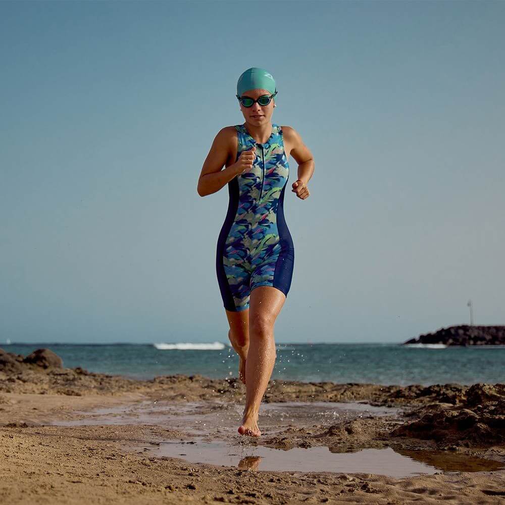 A child running on the beach wearing a Digital Print Trisuit, designed for triathlon competition and training.