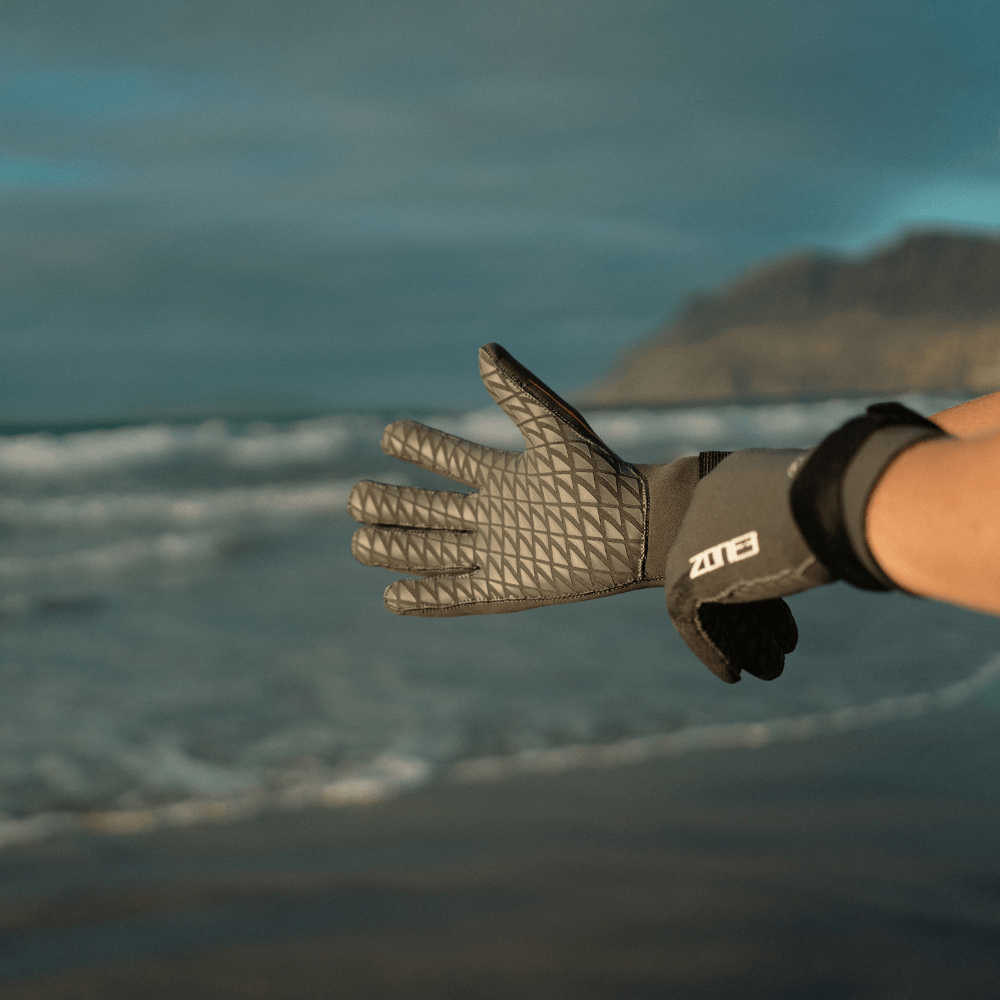 Person showing Active-Flex Swim Gloves on the beach, ideal for swimming and paddle sports.