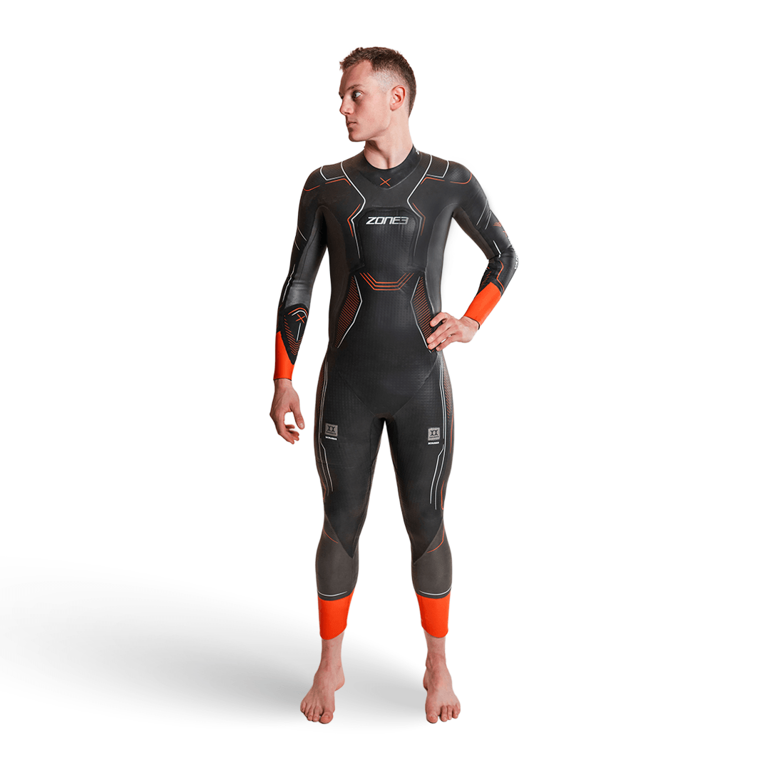 Front view of a man wearing the Zone3 Vanquish-X wetsuit with orange accents on white background. 