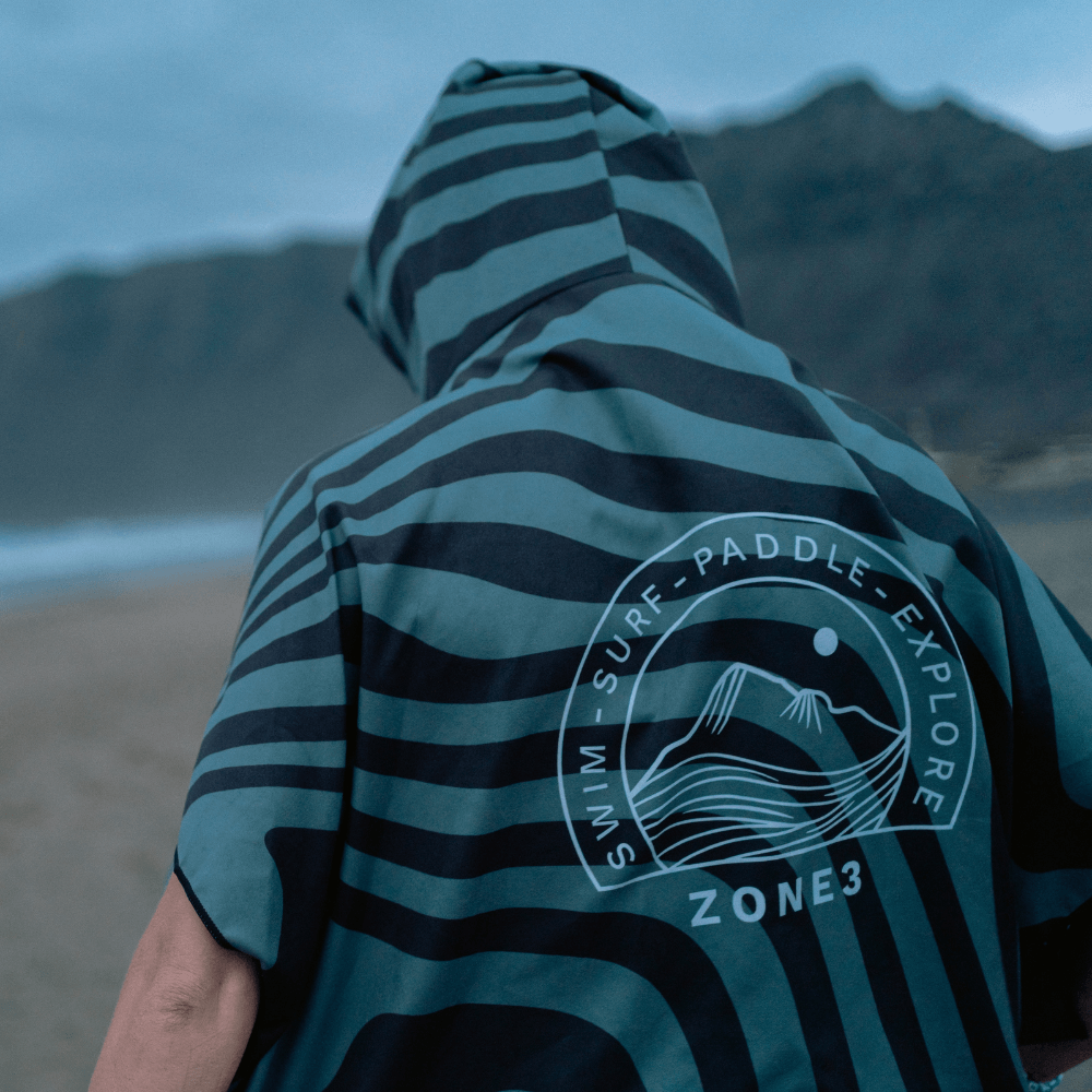Person wearing a Microfibre Changing Robe with stripes, perfect for outdoor activities and staying dry.