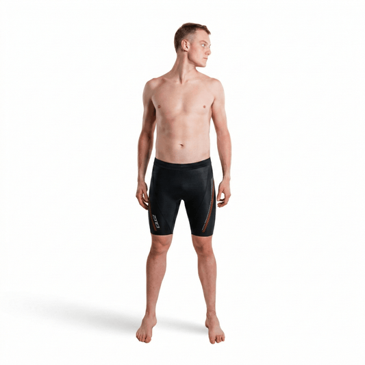 Front view of a shirtless man wearing premium 5/3mm buoyancy shorts in black with red panel accents.